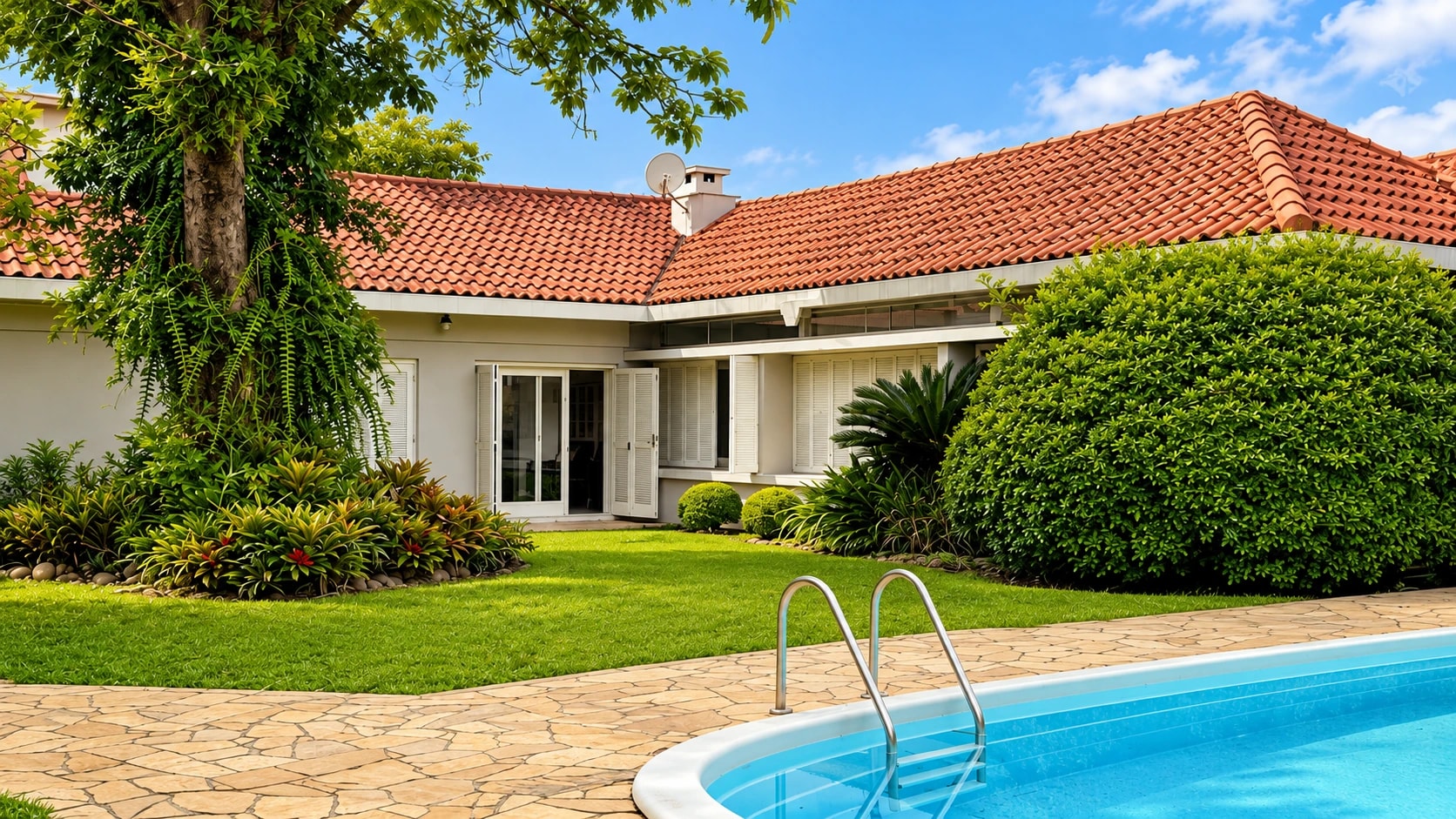 Área externa do Lar Bom Jardim com jardim, casa térrea e piscina